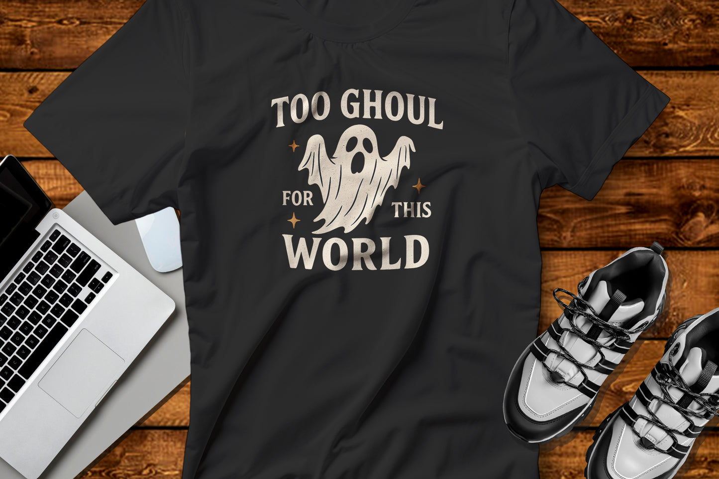 Black t-shirt with ghost graphic Too Ghoul For This World on a wooden surface featuring a laptop and shoes. for Halloween Gifts