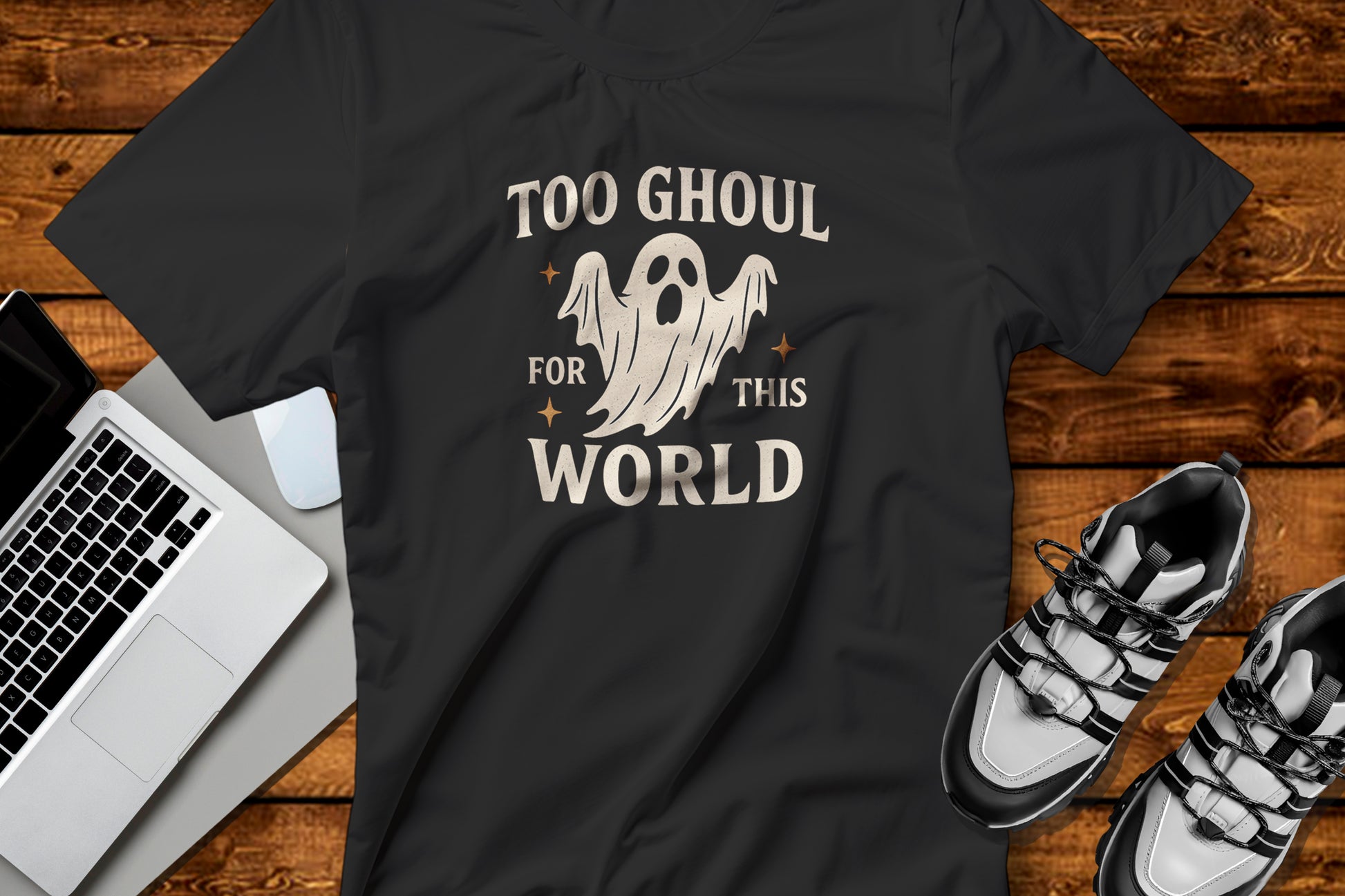 Black t-shirt with ghost graphic Too Ghoul For This World on a wooden surface featuring a laptop and shoes. for Halloween Gifts